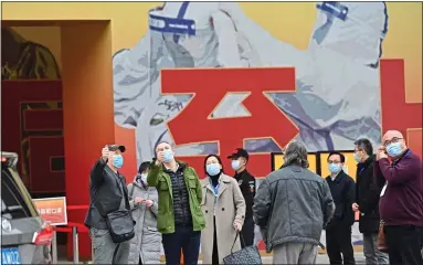  ?? ?? PROPAGANDA? The WHO inspectors gathered outside an exhibition on Covid-19 in Wuhan yesterday