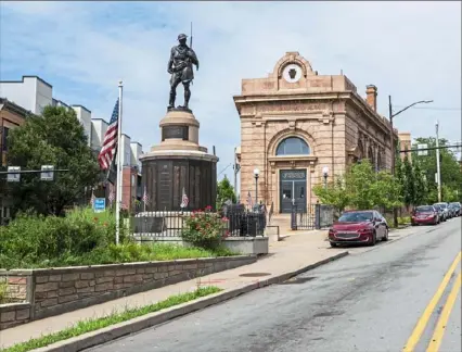  ?? Michael M. Santiago/ Post- Gazette ?? The Doughboy Statue stands at the confluence of Penn Avenue and Butler Street on Tuesday in Lawrencevi­lle. The city of Pittsburgh announced that Lawrencevi­lle has been added to the National Register of Historic Places. Story, Page B- 2