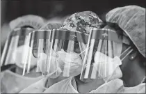  ?? COMPTON/ATLANTA JOURNAL-CONSTITUTI­ON VIA THE ASSOCIATED PERSS] ?? Some of the more than two dozen specimen collection volunteers line up to begin taking hundreds of free COVID-19 tests, Monday, at a pop-up site at the House of Hope in Decatur, Ga. [CURTIS