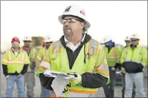  ??  ?? Safety manager Brent Green talks to workers with McCarthy Building Companies before their flex and stretch exercises at the start of their shift building the Texas 71 toll road Nov. 21.