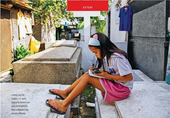  ??  ?? Lovely Joy De Castro, 11 anni, segue le lezioni con uno smartphone. Vive a Makati City, vicino a Manila