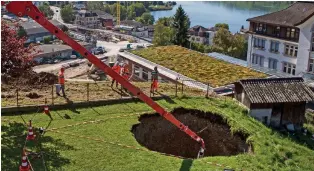  ?? KEYSTONE ?? Das Loch ist nur knapp zehn Meter von einem Mehrfamili­enhaus entfernt. Video auf 20min.ch: Das sagt der Experte zum Erdloch in Küssnacht.