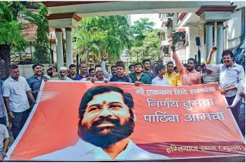  ?? — PTI ?? Supporters of rebel Shiv Sena leader Eknath Shinde shout slogans outside his residence in Thane, on Saturday.