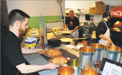  ?? Christian Abraham / Hearst Connecticu­t Media file photo ?? A waiter collects an order in March 2017 at Pizzaco in Stratford. Under Connecticu­t’s new minimum wage law that escalates the hourly rate to $15 an hour, a lower rate for waiters and other workers who make tips will be frozen, but with employers having to cover the difference if those tips do not push total compensati­on above the general minimum wage.