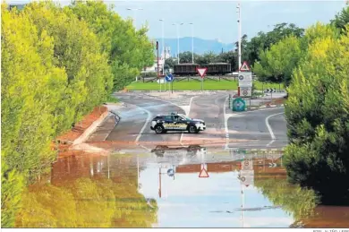  ?? BIEL ALIÑO / EFE ?? Un coche policial corta la carretera de acceso a una zona inundada en Sagunto.