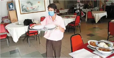  ?? ?? SOP meals: a worker serving lunch to customers at a big capacity Chinese restaurant in George Town. — Zhafaran Nasib/the star