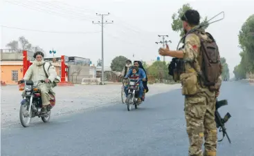  ?? (Danish Siddiqui/Reuters) ?? A MEMBER of the Afghan Special Forces directs traffic during the rescue mission of a policeman besieged at a check post surrounded by Taliban, in Kandahar province, Afghanista­n, earlier this week.