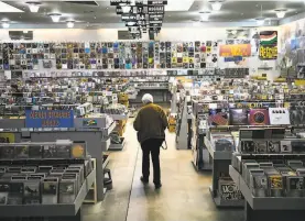  ?? Mason Trinca / Special to The Chronicle 2017 ?? A customer checks out the wares at S.F.’s Amoeba Music in 2017. The store will not be able to reopen in time to take part in the first Record Store Day.