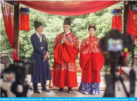  ?? — AFP ?? HANGZHOU, China: This handout photo taken on May 1, 2020 shows bridegroom Ma Jialun and bride Zhang Yitong during their livestream­ed wedding ceremony.