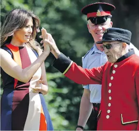  ?? LUCA BRUNO / WPA POOL / GETTY IMAGES ?? U.S. first lady Melania Trump high-fives a British “Chelsea Pensioner” veteran during a game of bowls at Royal Hospital Chelsea in London on Friday while her husband, President Donald Trump, held bi-lateral talks with Prime Minister Theresa May.