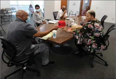  ?? (Arkansas Democrat-Gazette/Thomas Metthe) ?? Metropolit­an Housing Alliance board member Leta Anthony (right) gives a Little Rock hat to outgoing interim executive director Andy Delaney during the MHA board meeting on Thursday in Little Rock.