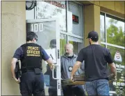  ?? KARLMONDON/STAFF ?? San Jose police and district attorney investigat­ors take part in a raid on San Jose Organics pot dispensary on Thursday.