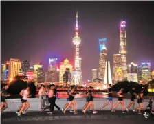  ?? AFP ?? A growing number of running groups in Shanghai head out each night, despite the dangers
