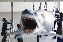  ?? AP PHOTO/ CHRIS PIZZELLO ?? A fiberglass replica of Bruce, the shark featured in Steven Spielberg’s classic 1975 film “Jaws,” is lifted into a suspended position for display at the new Academy of Museum of Motion Pictures last Friday.