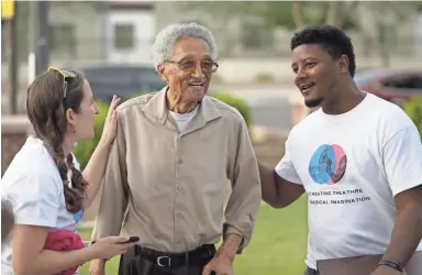  ??  ?? Arizona State University theater graduate students Claire K. Redfield. left, and Donta McGilvery, right, greet Calvin C. Goode as he comes to see a performanc­e in May at Eastlake Park in Phoenix.