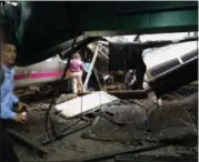  ?? WILLIAM SUN — THE ASSOCIATED PRESS ?? In a photo provided by William Sun, people examine the wreckage of a New Jersey Transit commuter train that crashed into the train station during the morning rush hour in Hoboken,, N.J., on Thursday, killing one woman and injuring dozens.