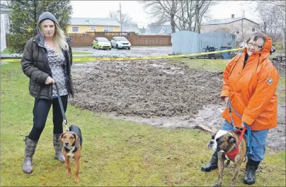  ?? SHARON MONTGOMERY-DUPE/CAPE BRETON POST ?? Jessie Bainbridge, left, with her dog Spartacus, and Cathy Crosby, with her dog Bubba, stand near their apartment complex on Dominion Street, Glace Bay, where a sinkhole was filled in on Thursday morning. Bainbridge and Crosby said residents are...