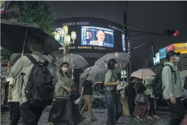  ?? BLOOMBERG ?? Pedestrian­s walk past a screen broadcasti­ng Japan’s prime minister, Yoshihide Suga, declaring a fourth coronaviru­s state of emergency in Tokyo on Thursday.