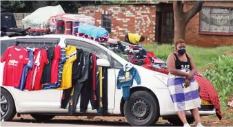  ?? — Picture: Kudakwashe Hunda ?? An illegal vendor defies national Covid-19 lockdown rules as she displays clothes for sale near theWarren Park D roundabout in Harare recently.