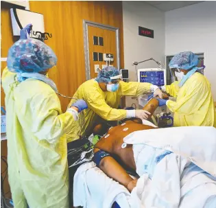  ?? NATHAN DENETTE / THE CANADIAN PRESS FILES ?? Health-care workers turn a COVID-19 patient who is intubated and on a
ventilator from his back to his stomach at Humber River Hospital.