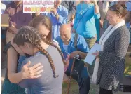  ?? GREG SORBER/JOURNAL ?? Courtney Al-bumohammed, left, cries in the arms of Sayrah Namaste as Kadhim Al-bumohammed, center, and his wife, Reeham Majedd, right, speak to supporters protesting outside the U.S. Immigratio­n and Customs Enforcemen­t field office on Monday.