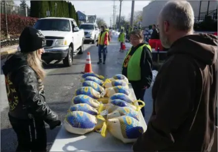  ?? FRAN MAYE — DIGITAL FIRST MEDIA ?? Dot Smrke (left) prepares to hand out turkeys to needy families during a turkey giveaway Saturday morning in Kennett Square.