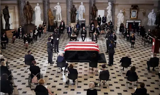  ?? Getty Images ?? Members of Congress and guests pay their respects to the late Supreme Court Justice Ruth Bader Ginsburg as her casket lies in state during a memorial service in her honor in the Statuary Hall of the Capitol on Friday in Washington, D. C.