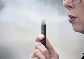  ?? AP FILE ?? A woman exhales a puff of vapor from a Juul pen in Vancouver, Wash.