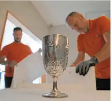  ?? ?? art handlers prepare the Spyros louis Cup to be transporte­d to the louvre for an exhibition timed to coincide with the paris Olympics.