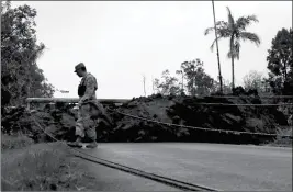  ?? ASSOCIATED PRESS ?? FIRST LT. AARON HEW LEN, OF THE U.S. NATIONAL GUARD, tests air quality near cracks that are emitting toxic gases from a lava flow in the Leilani Estates subdivisio­n near Pahoa, Hawaii, on Tuesday. Scientists confirm that volcanic activity has paused at...