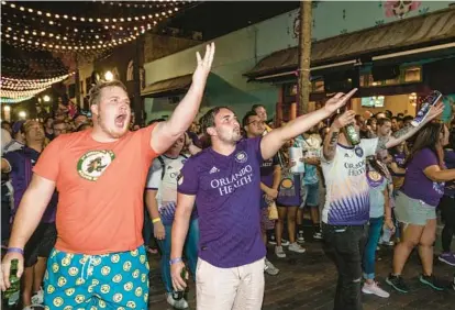  ?? WILLIE J. ALLEN JR./ORLANDO SENTINEL ?? Orlando City soccer fans Shawn Berg (left) and Michael Hilton (second from left) at the official watch party in the Wall Street Plaza did not like a referee’s call as the Lions took on host CF Montréal in the first round of MLS playoffs.