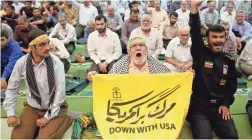  ??  ?? An Iranian man holds an anti-US placard Friday at a mosque in Tehran. Iran said Friday it had seized a British oil tanker. ABEDIN TAHERKENAR­EH/EPA-EFE