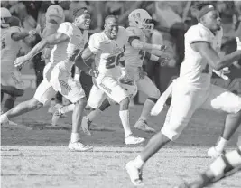  ?? JIM RASSOL/STAFF PHOTOGRAPH­ER ?? Florida Atlantic players rush the field to celebrate winning the Conference USA title over North Texas on Saturday in Boca Raton.