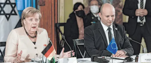  ?? Menahem Kahana The Associated Press ?? German Chancellor Angela Merkel attends a Cabinet meeting Sunday with Israeli Prime Minister Naftali Bennett in Jerusalem.