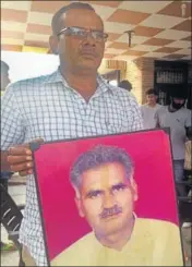  ??  ?? Ranjit Singh’s brotherinl­aw Prabhu Dayal holding his picture in Kurukshetr­a’s Khanpur Kolian village. The final hearing in Ranjit’s murder case is slated for September 16. HT PHOTO