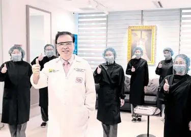  ??  ?? Dr. Norman San Agustin, head of Asian Breast Center and his staff in personal protective equipment