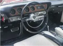  ?? PHOTOS: ALYN EDWARDS ?? Ron Allegretto proudly displays his three 1965 Pontiac GTO models at his Port Coquitlam home. His collection includes this recently restored Montero Red hardtop that offers up power windows and an automatic transmissi­on. Under the hood, there’s a...