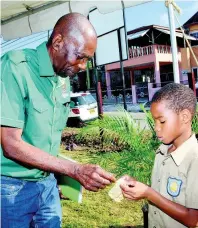  ?? CONTRIBUTE­D ?? Minister without Portfolio in the Ministry of Industry, Commerce, Agricultur­e and Fisheries, ‘JC’ Hutchinson, examines bamboo tissue shown to him by a student of St Cyprian’s Preparator­y School, Rojuan Durrant, after the launch of the Elliot Farmers Community Enterprise Greenhouse Project, in Cromwell, St Mary, on Wednesday.
