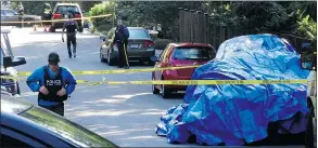  ?? — BOB MACKIN ?? A vehicle is covered by a tarp Tuesday as North Vancouver RCMP probe a homicide on Wellington Drive, east of Sykes Road. It was the second gangland slaying in Metro Vancouver in three days.