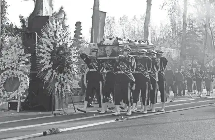  ?? IRANIAN DEFENSE MINISTRY VIA AP ?? Military personnel carry the coffin of nuclear scientist Mohsen Fakhrizade­h, killed Friday, in a funeral ceremony Monday in Tehran, Iran.