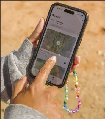  ?? PHOTOS BY DANNY DUARTE — THE NEW YORK TIMESH ?? Hike Clerb founder Evelynn Escobar shows the Alltrails app at Will Rogers State Historic Park on March 24in the Pacific Palisades area of Los Angeles. Alltrails has maps for thousands of trails in the U.S. and around the world. With an Alltrails+ subscripti­on, hikers can save the maps for offline use.