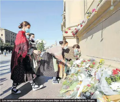  ?? ÁNGEL DE CASTRO ?? Los zaragozano­s se acercaron a la basílica para dejar sus ramos en la talla de la Virgen.