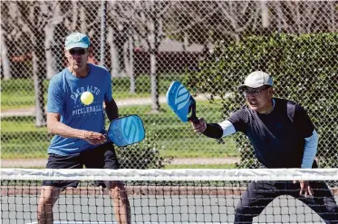  ?? Photos by Lea Suzuki/The Chronicle ?? Ron Friedman, left, of Menlo Park and Austin Liu of Palo Alto play at the Mitchell Park Courts in Palo Alto on Thursday. Both men say they have suffered injuries playing pickleball.