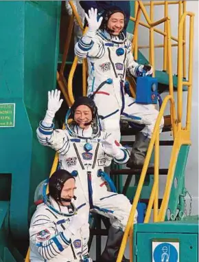  ?? AFP PIC ?? Japanese billionair­e Yusaku Maezawa (centre), his assistant Yozo Hirano (top) and Russian cosmonaut Alexander Misurkin boarding the Soyuz MS-20 spacecraft prior to its launch at the Baikonur cosmodrome in Kazakhstan yesterday.