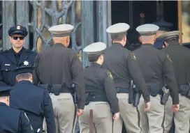  ??  ?? Top: Friends and family hug after funeral services for Stacee Etcheber at St. Mary's Cathedral in San Francisco. Above: Officers from Las Vegas Metropolit­an Police Department attend the serivce.