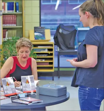  ?? Photos by Matthew Liebenberg ?? Author Gaylene Guillemin signs a book during her appearance at the Swift Current Branch Library, June 7.