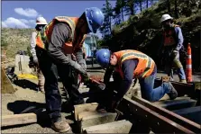  ?? PHOTOS BY MATTHEW JONAS — STAFF PHOTOGRAPH­ER ?? Carpenters Cesar Molina, left, and Hector Escarcega, both with SEMA Constructi­on, work on concrete forms for a wall along Fourmile Canyon Drive near Logan Mill Road in Boulder County in 2018.