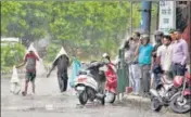  ?? PTI ?? ■ People take shelter during heavy rain in Jammu on Saturday.