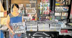  ?? —AFP ?? LAST STAND A news kiosk owner shows a copy of the Apple Daily newspaper’s final edition in Hong Kong’s Central district on June 24.