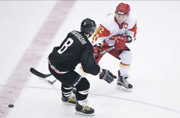  ?? MATT ROBERTS/GETTY IMAGES ?? Japan’s Seiji Takahashi and Chongwei Wang of China vie for the puck at the Sapporo Asian Winter Games. Hockey in Japan has never fulfilled the promise of Nagano.